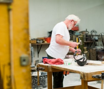 man in werkplaats aan het beelhouwen
