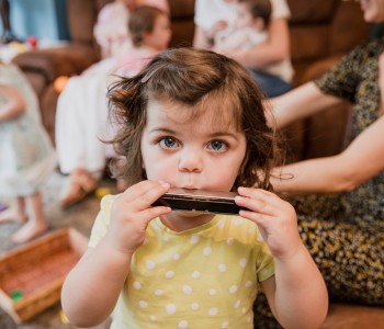 Een afbeelding van een kind dat mondharmonica speelt