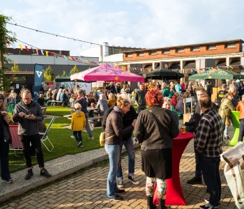 bezoekers op festivalterrein met elkaar pratend